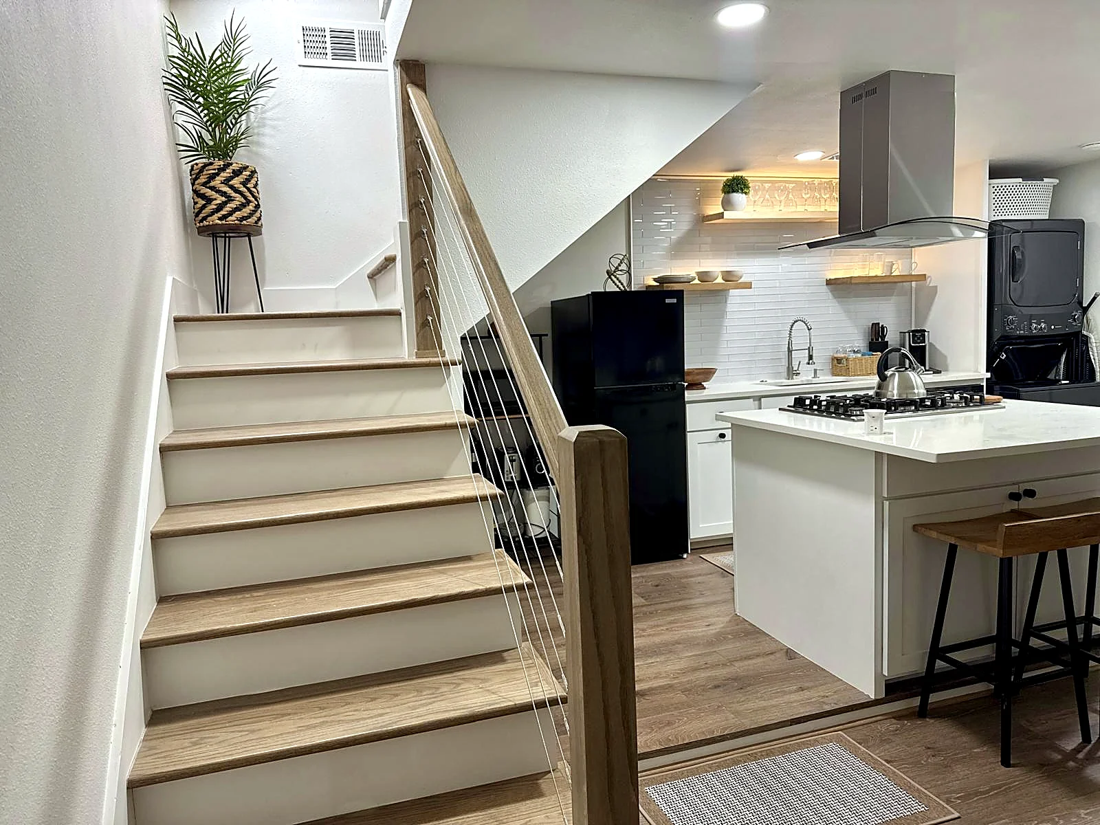 Garage apartment living area — Stair with built-in drawers and cabinets in a bright living space.